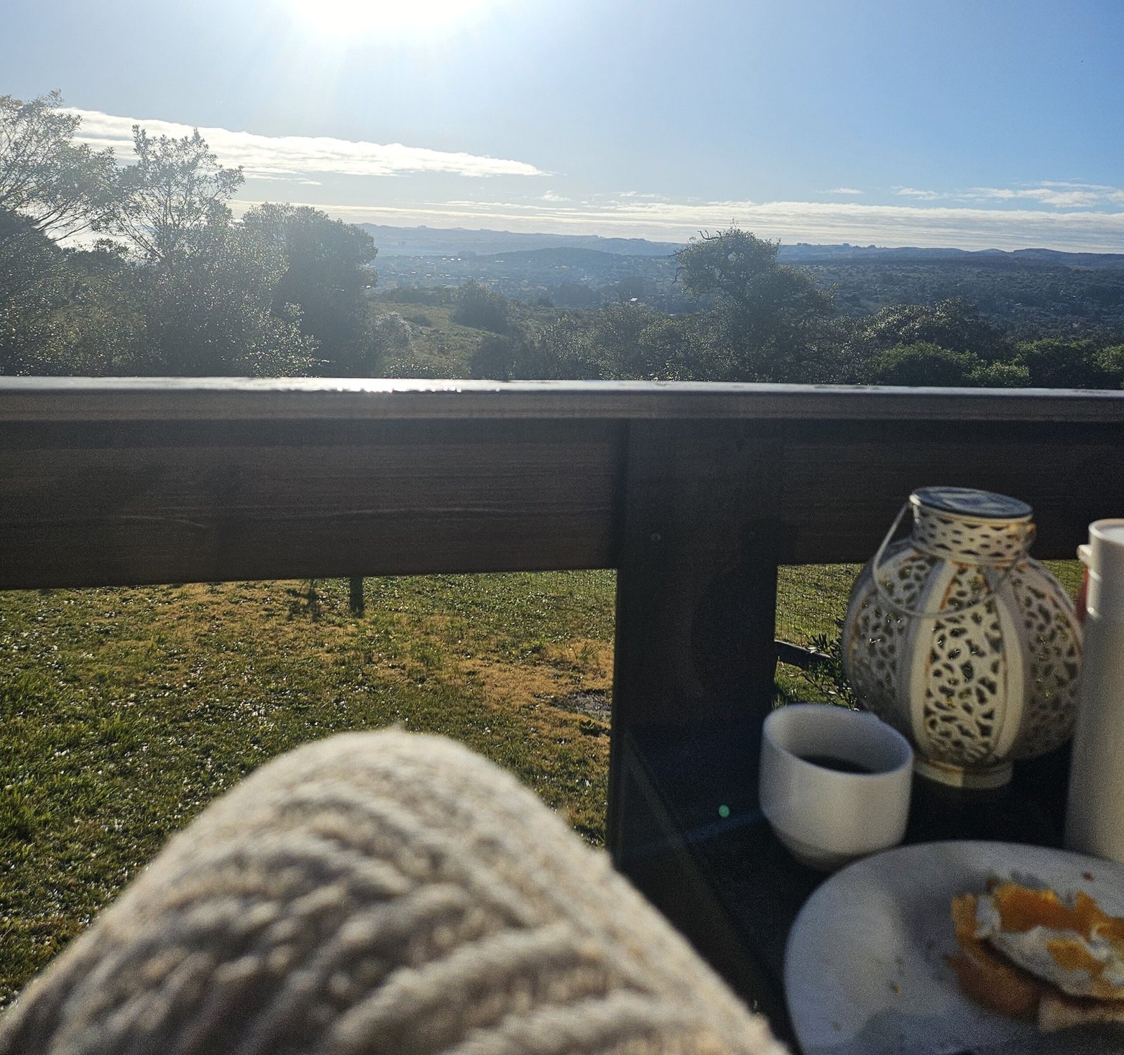 A cozy morning scene with a breakfast setup overlooking a sunny green landscape.